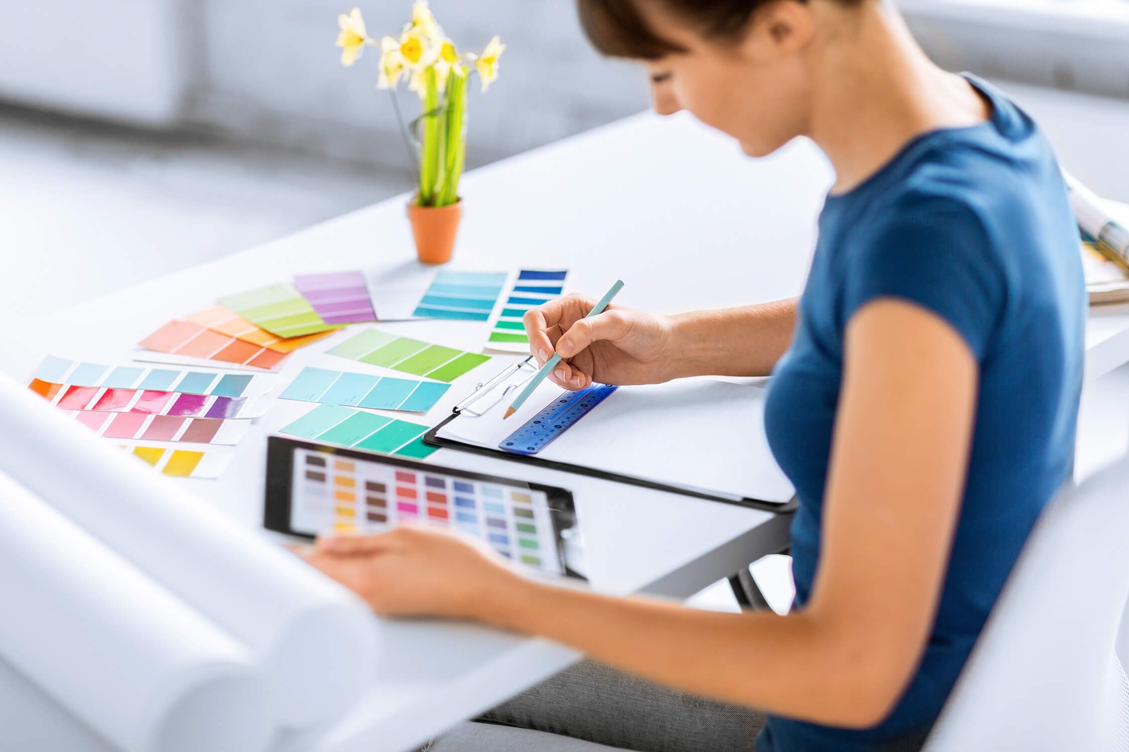 Designerin mit Farbfächer bei der Farbauswahl